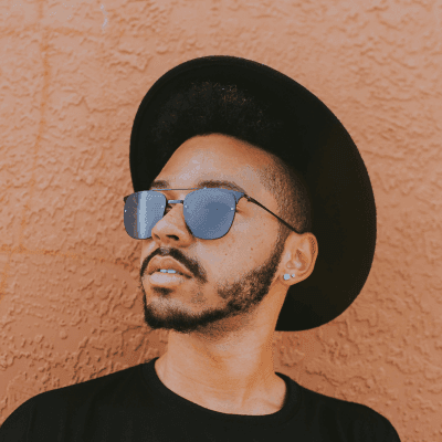 man leaning on brown wall