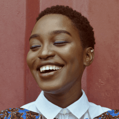 woman smiling beside red wall