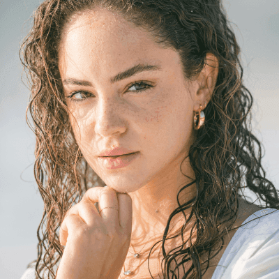 a woman with curly hair wearing a white dress