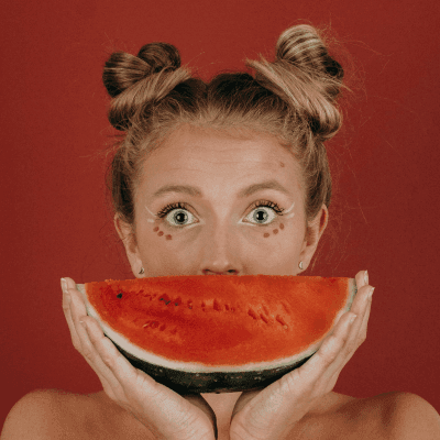 woman covering her mouth with watermelon