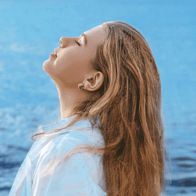 woman in white shirt standing near sea during daytime