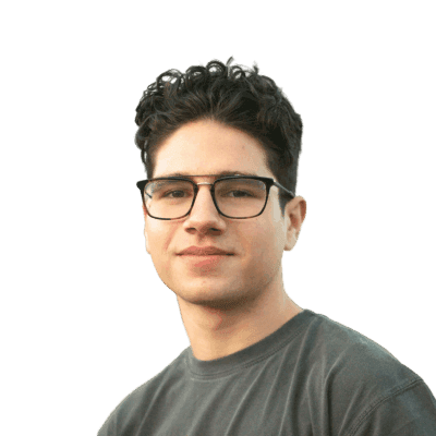 a young man wearing glasses standing in front of a mountain